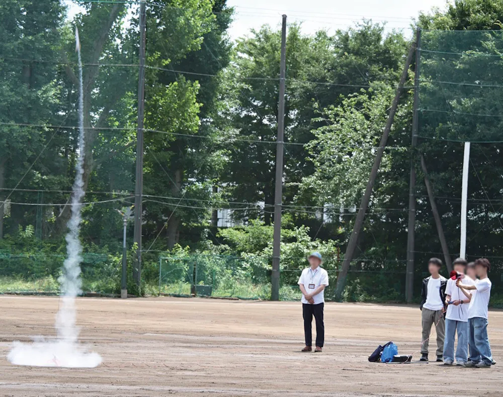グラウンドでモデルロケットの打ち上げの様子