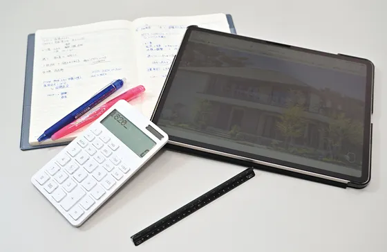 ノート、タブレット、電卓、三角スケールなどの仕事道具
