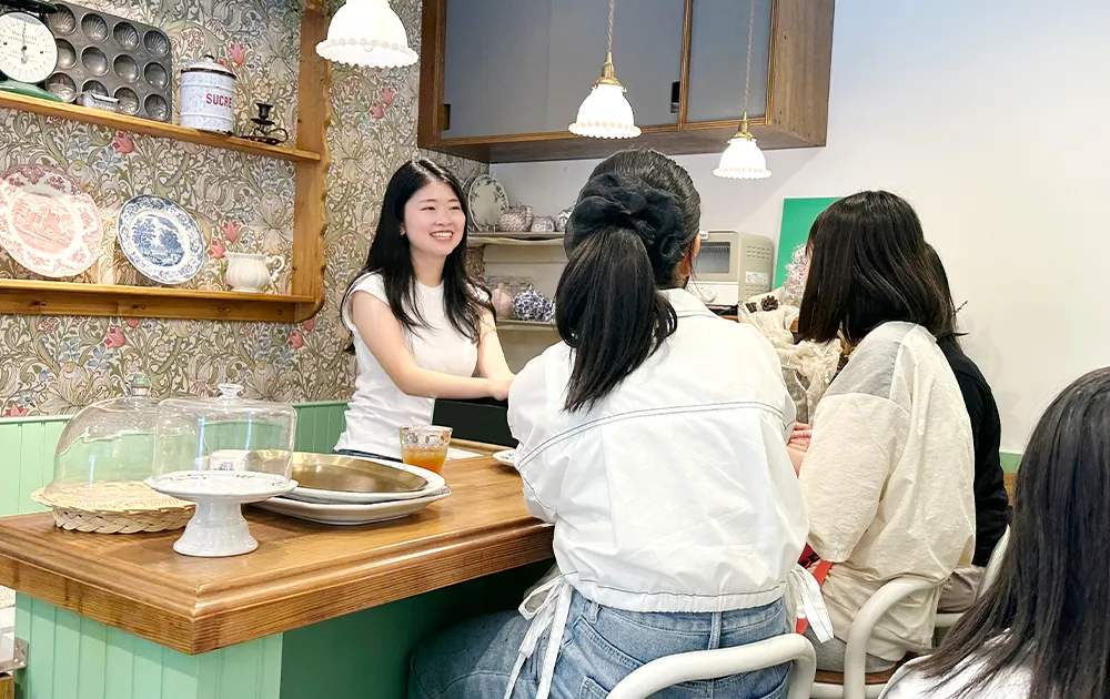 カフェを訪れた後輩たちに文化祭に向けてアドバイス。卒業後も母校とのつながりは続いています