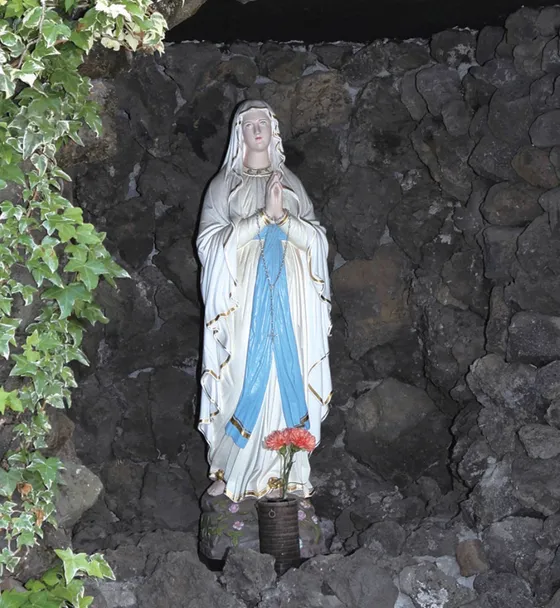 白いマリア像が安置された「ルルドの洞窟」。校庭の一角にあり、生徒がいつでもお祈りできます