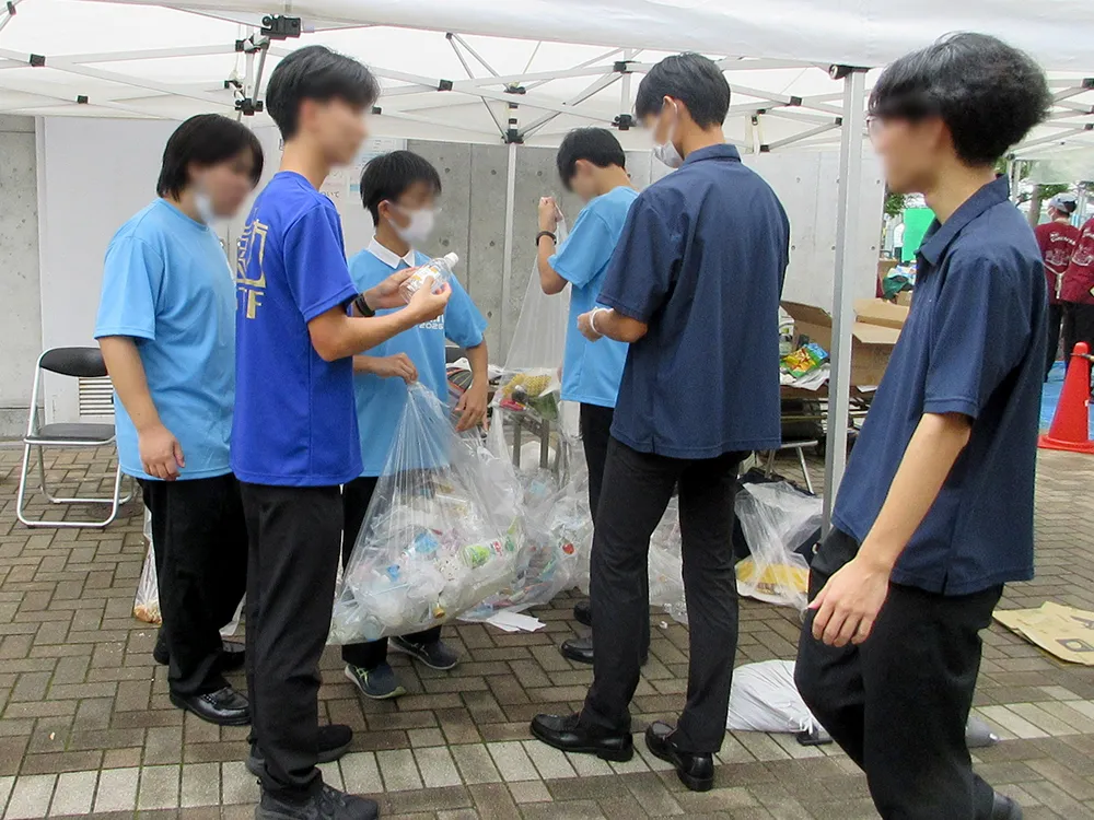 一つひとつ手に取ってごみの分別をする環境委員の生徒。文化祭の成功には、こうした生徒の取り組みもあります