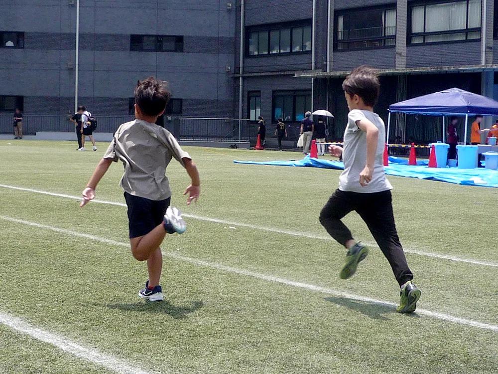 鎌学のグラウンドで50メートル走体験。小学生が元気いっぱい走っていました